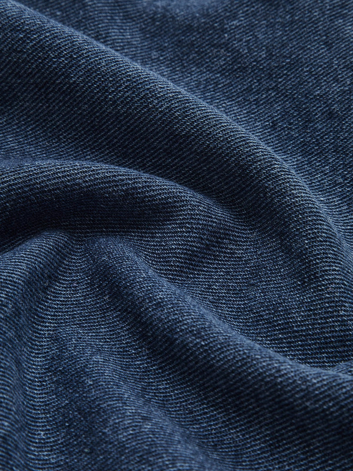 Zoom sur le tissu en denim bleu de la veste 'Sylpha' pour femme, mettant en valeur la texture douce et de qualité du denim. Cette image illustre la souplesse et la finition moderne de cette veste décontractée, idéale pour un look casual et élégant.
