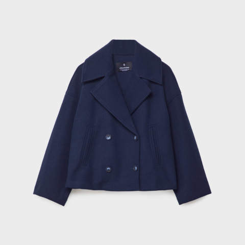 Manteau court bleu marine à double boutonnage, col large façon tailleur et coupe ample, présenté sur fond clair.