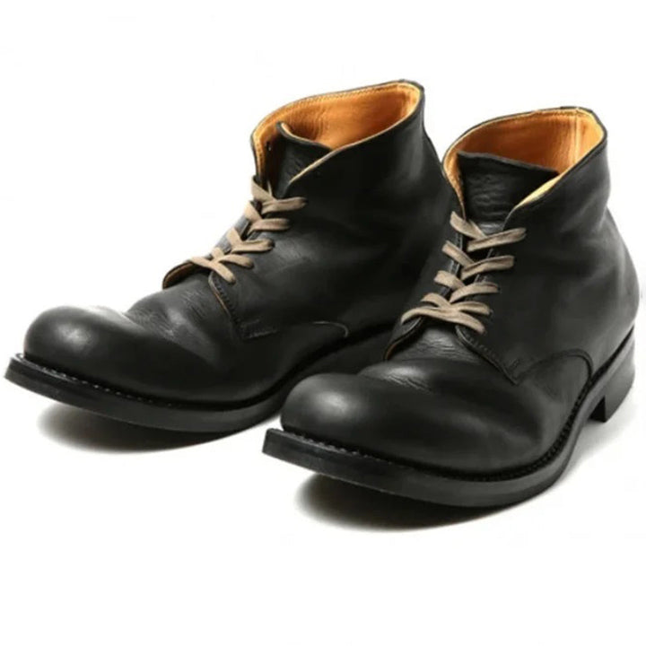 Paire de bottes pour homme en cuir noir, élégantes et robustes, avec un intérieur beige contrastant et des lacets gris-beige. Les chaussures présentent une finition brillante et une semelle solide conçue pour un confort et une durabilité exceptionnels. Disposées sur un fond blanc, elles dégagent un style intemporel et professionnel, parfait pour une tenue habillée ou décontractée.