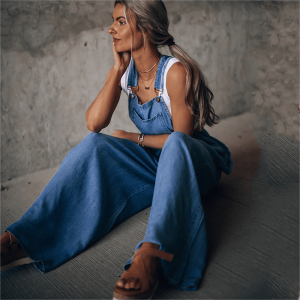 Combinaison en denim Tara pour femme, moderne et confortable, avec bretelles et coupe large fluide. Style décontracté chic, portée avec un top blanc, idéale pour un look tendance au quotidien.