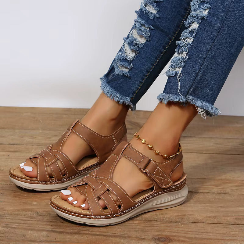 Modernes, coloris camel avec surpiqûres claires, brides ajourées et semelle confort épaisse, portées avec un jean sur sol en bois.