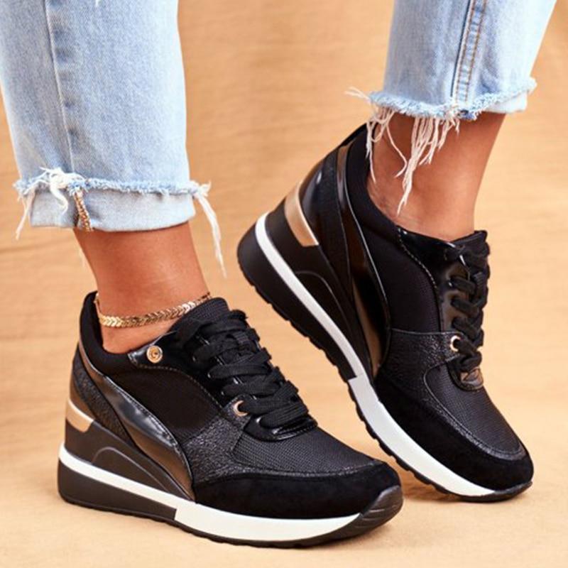 Une paire de baskets pour femme en noir et doré, combinant des matériaux brillants et mats avec des détails modernes. Ces chaussures de sport au design tendance possèdent une semelle compensée blanche et noire pour plus de confort et de style. Idéales pour un look urbain ou décontracté, elles sont portées ici avec un jean clair légèrement retroussé, parfaites pour un usage quotidien.