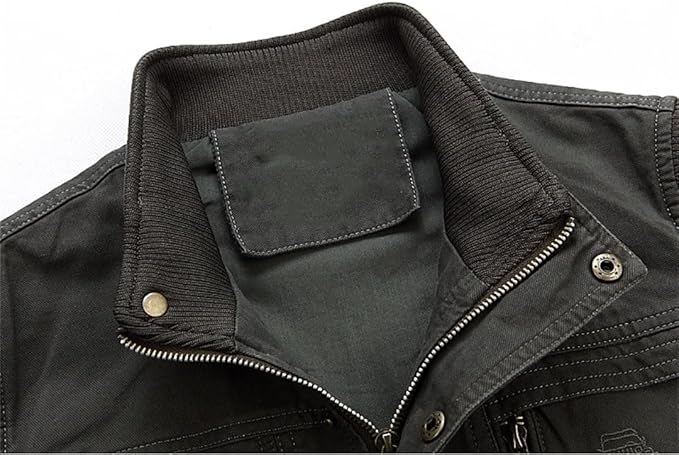 Gros plan sur le col montant côtelé du gilet kaki foncé, avec fermeture zippée métallique et boutons-pression, sur fond blanc.