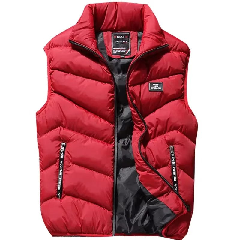 Gilet matelassé pour homme de couleur rouge vif avec fermeture éclair et poches latérales zippées. Ce modèle sans manches possède un col montant et une doublure intérieure sombre contrastante, offrant un style moderne et sportif. Parfait pour affronter le froid tout en gardant une allure élégante et dynamique pendant la saison hivernale.