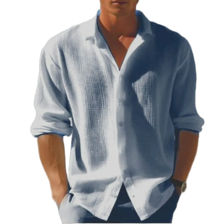 Chemise manches longues Ulysse pour homme, coupe moderne en tissu texturé bleu clair, portée avec un pantalon assorti, manches retroussées, style élégant décontracté.