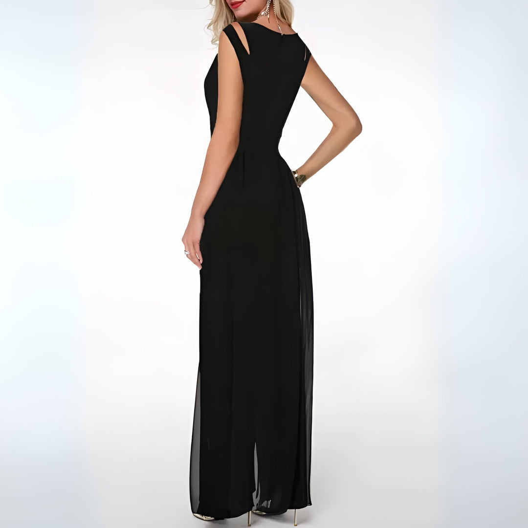 Combinaison d’été Ursuline pour femme, noire style fête, coupe longue et fluide avec épaules ajourées, vue de dos, portée avec talons.