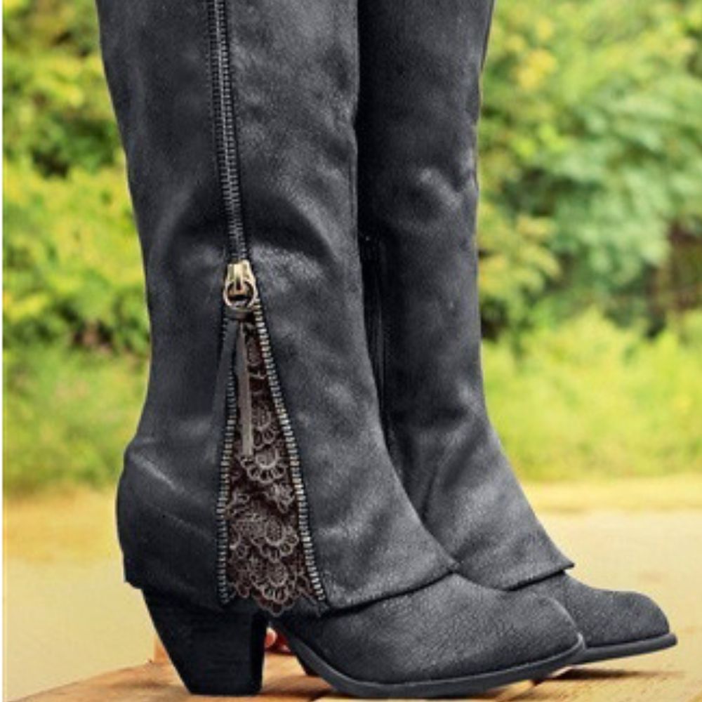 Bottes noires à talon carré, avec une fermeture éclair décorée de broderies fines sur le côté. La texture du cuir et les détails subtils ajoutent une touche élégante et moderne au style western.