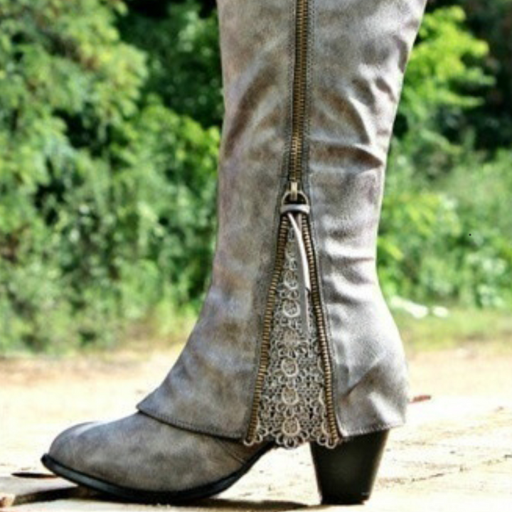 Botte grise à talon carré, avec une fermeture éclair décorée de broderies élégantes sur le côté. La texture du cuir ajoute de la profondeur à la chaussure, offrant à la fois confort et un style western moderne.