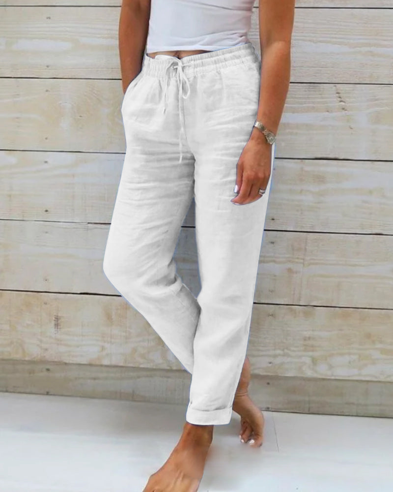 Un pantalon léger et élégant pour femme, de couleur blanche, avec un cordon de serrage à la taille et une coupe décontractée, idéal pour un look moderne et confortable.