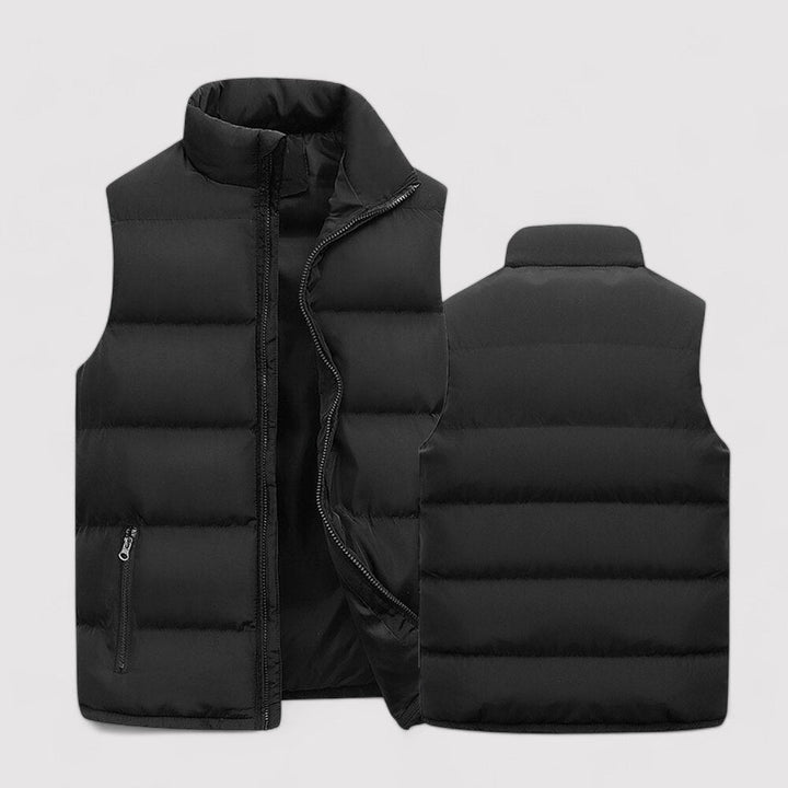 Gilet sans manches noir pour homme, matelassé avec des poches latérales zippées et un col montant. Ce gilet léger et chaud est parfait pour un style décontracté et confortable en toute saison.