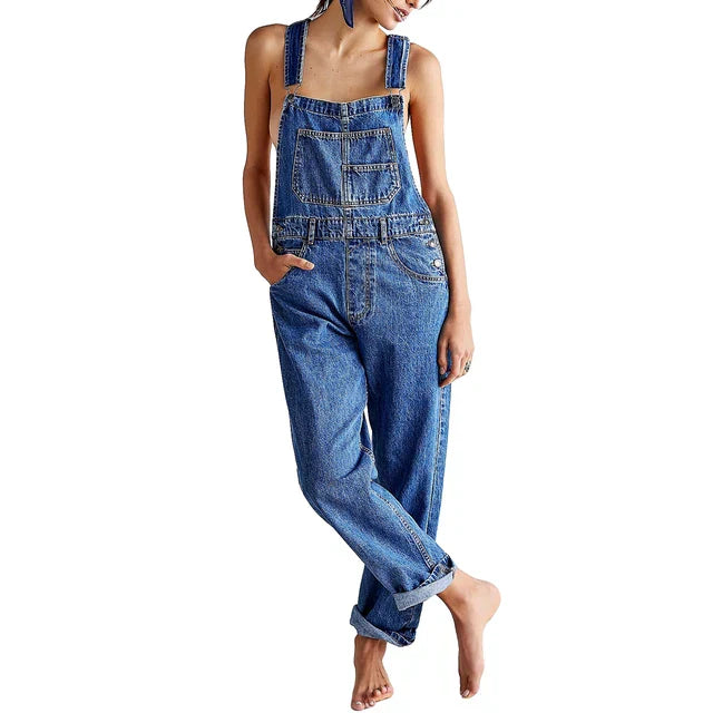 Femme portant la combinaison moderne Veloria en jean bleu, style salopette à bretelles avec poche poitrine et jambes droites, look casual décontracté.