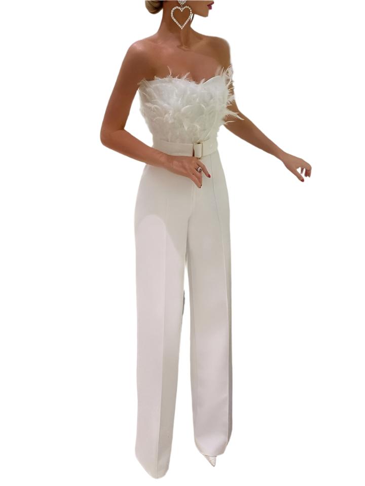 Une combinaison blanche élégante pour femme avec un bustier orné de plumes et un pantalon à coupe large. Accessoires en forme de cœur pour un look moderne et sophistiqué.