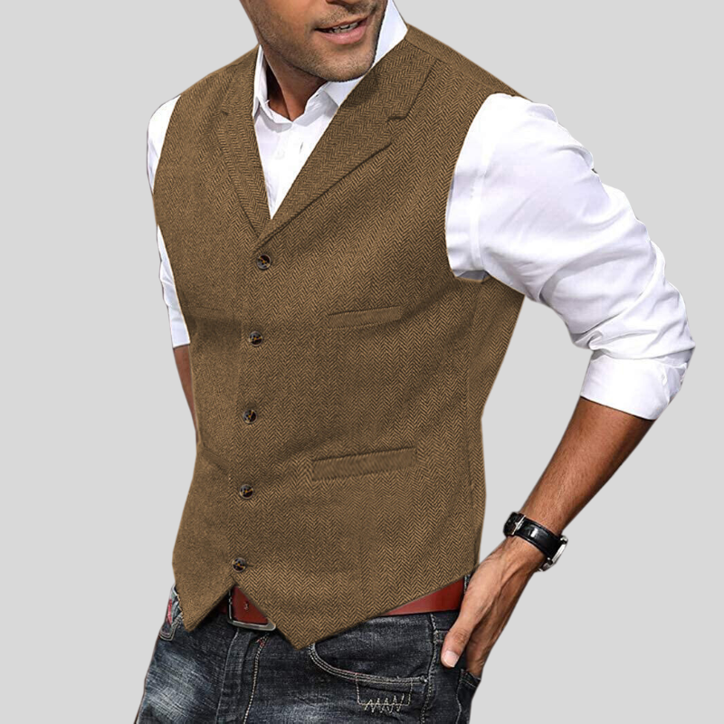 Gilet court pour hommes Virgile moderne, coloris camel/marron à motif chevrons, coupe ajustée avec boutons et poches, porté sur chemise blanche avec jean.
