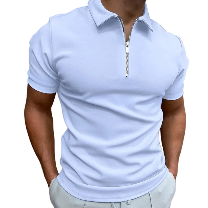 Polo pour homme bleu clair à manches courtes, coupe ajustée et moderne, avec col structuré et fermeture zippée, porté avec un pantalon clair pour un look élégant et contemporain.