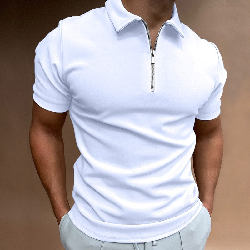 Polo pour homme blanc à manches courtes, coupe ajustée et moderne, avec col structuré et fermeture zippée, porté avec un pantalon clair pour un style élégant, minimaliste et contemporain.