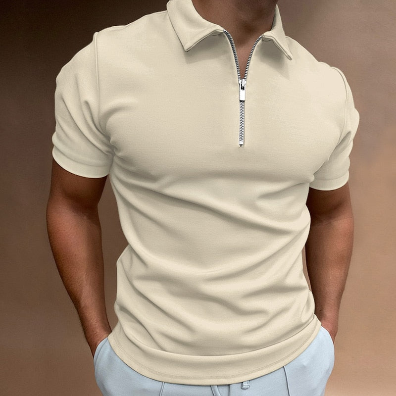 Polo pour homme couleur crème à manches courtes, coupe ajustée et moderne, avec col structuré et fermeture zippée, porté avec un pantalon clair pour un style élégant, épuré et contemporain.