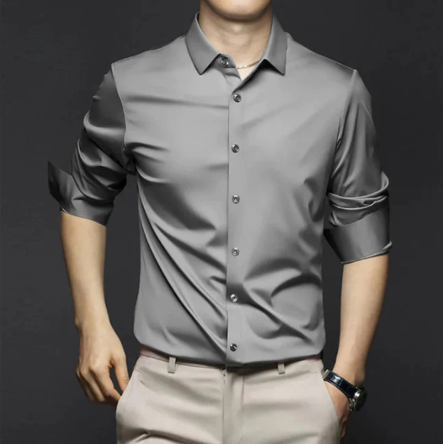 Chemise d’été Wulfric pour homme, grise moderne à manches longues retroussées et boutonnée, coupe élégante portée avec pantalon beige.