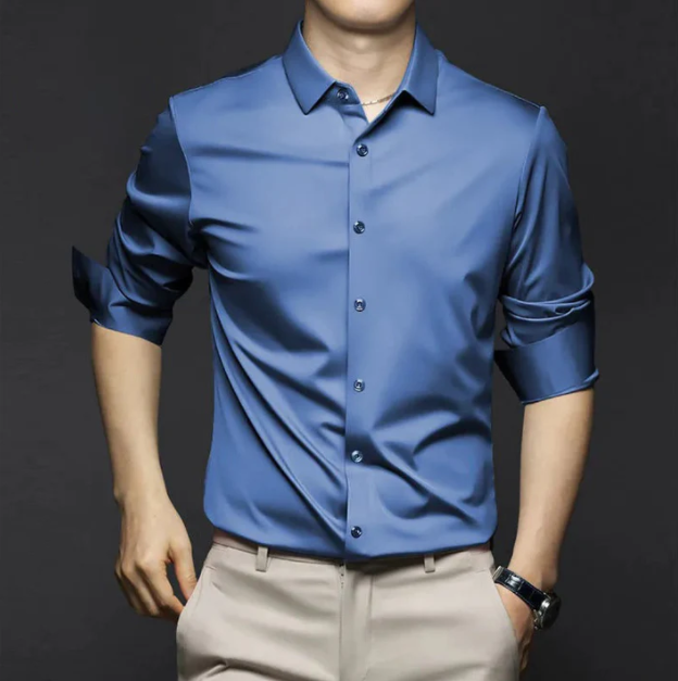 Chemise d’été Wulfric pour homme, bleue moderne à manches longues retroussées et boutonnée, coupe élégante portée avec pantalon beige.