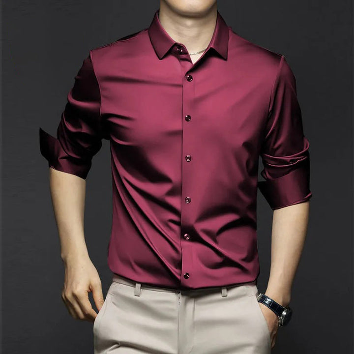 Chemise d’été Wulfric pour homme, bordeaux moderne à manches longues retroussées et boutonnée, coupe élégante portée avec pantalon beige.