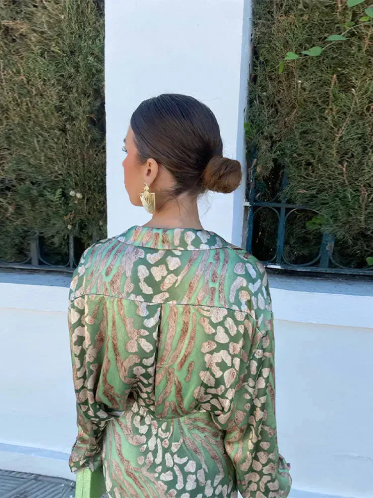 Vue de dos de la robe d’été Wynéa à manches longues, coupe chemise en satin vert avec imprimé doré, tombé fluide et taille ceinturée.