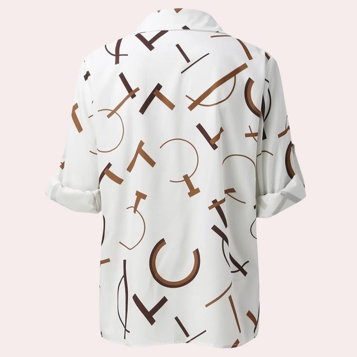 Vue arrière de la chemise femme Xavine blanche avec motif de lettres graphiques marron. Coupe fluide avec manches retroussées, idéale pour un style tendance, moderne et décontracté.