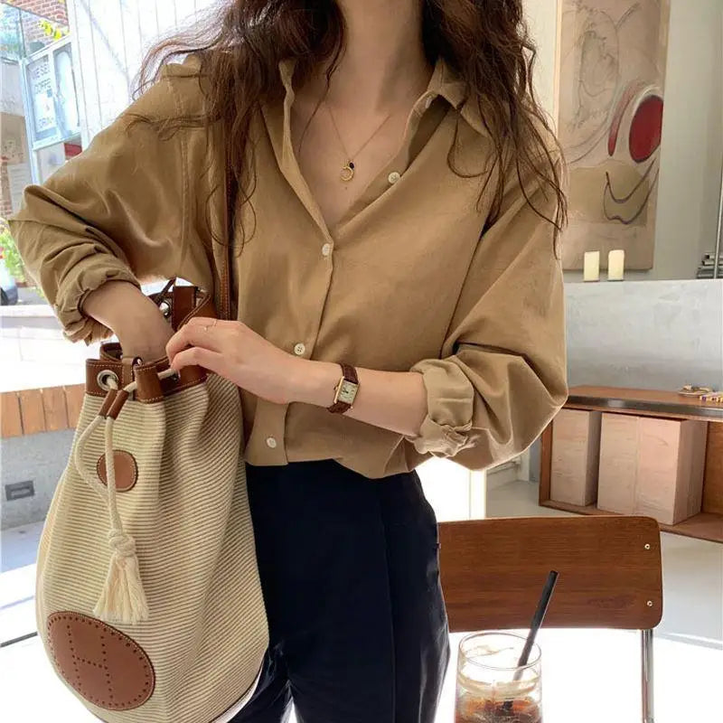 Polo Xénia pour femme, à manches longues, de couleur beige élégante. Ce modèle moderne, avec un col classique et des boutons en façade, est parfait pour un look chic et décontracté, idéal pour les journées d'automne ou les occasions casual.