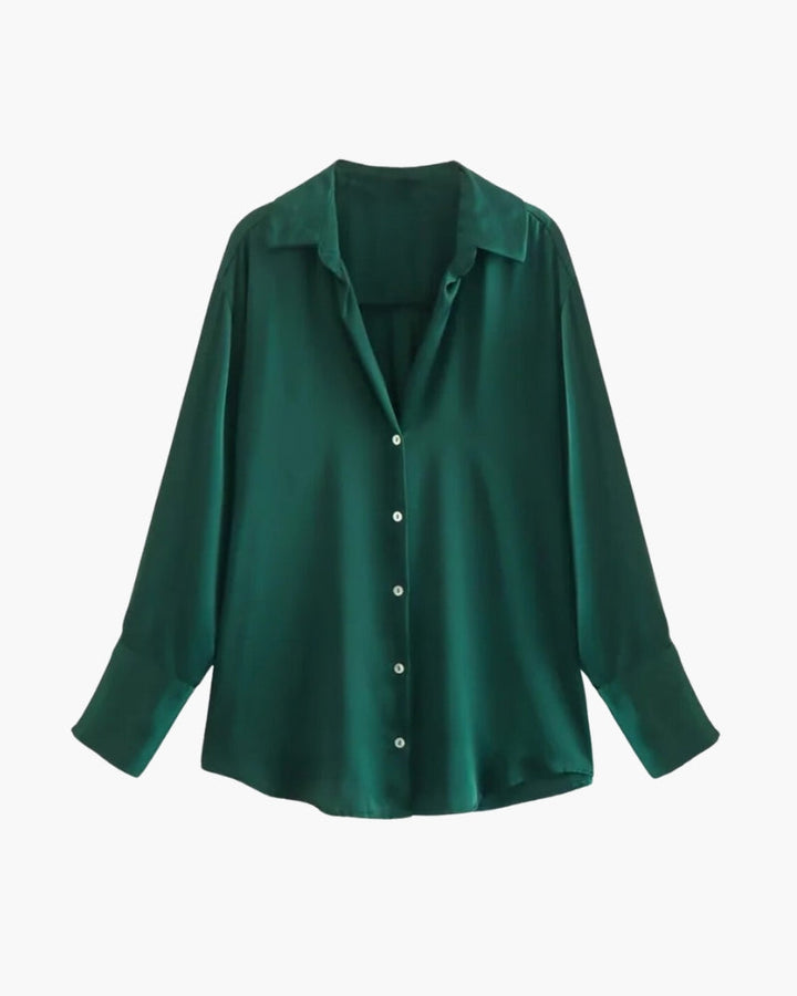 Polo Xénia pour femme, à manches longues, de couleur vert émeraude. Ce modèle moderne, avec un col classique et des boutons en façade, est parfait pour un look élégant et raffiné, idéal pour un style chic et décontracté.