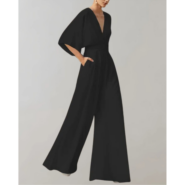 Combinaison fluide noire à col V, manches amples et pantalon large, taille marquée, portée par un mannequin sur fond neutre.