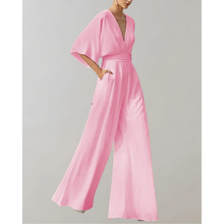 Combinaison fluide rose à col V, manches amples et pantalon large, taille marquée, portée par un mannequin sur fond neutre.