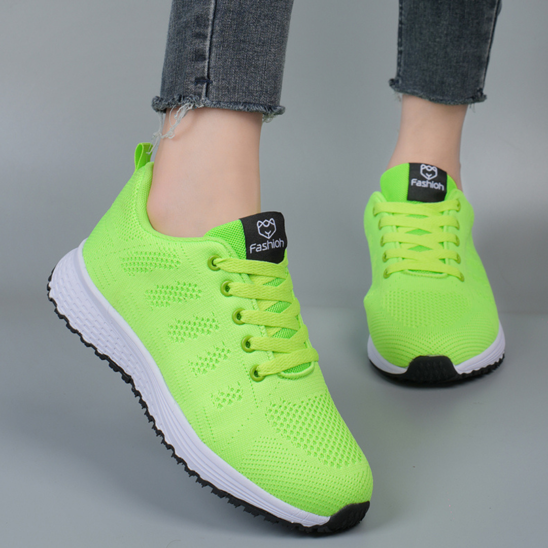 Femme portant les chaussures de sport Zoraida tendance, baskets vert fluo en maille respirante avec lacets assortis et semelle blanche légère, idéales pour un look sportif et confortable.