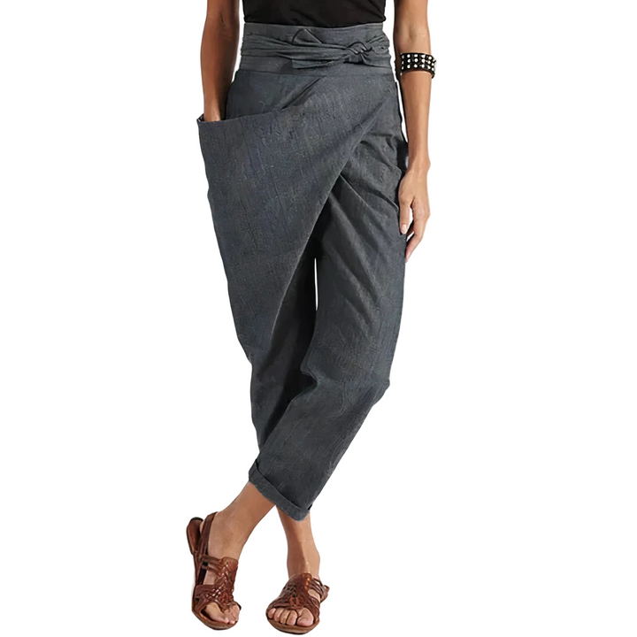 Pantalon d’été Zorine pour femme, gris anthracite style sarouel avec taille nouée et coupe ample, porté avec sandales, look tendance et décontracté.