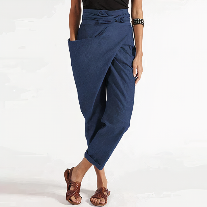 Pantalon d’été Zorine pour femme, bleu marine style sarouel avec taille nouée et coupe ample, porté avec sandales, look tendance et confortable.