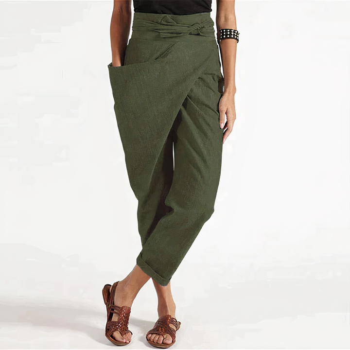Pantalon d’été Zorine pour femme, vert kaki style sarouel avec taille nouée et coupe ample, porté avec sandales, look tendance et décontracté.